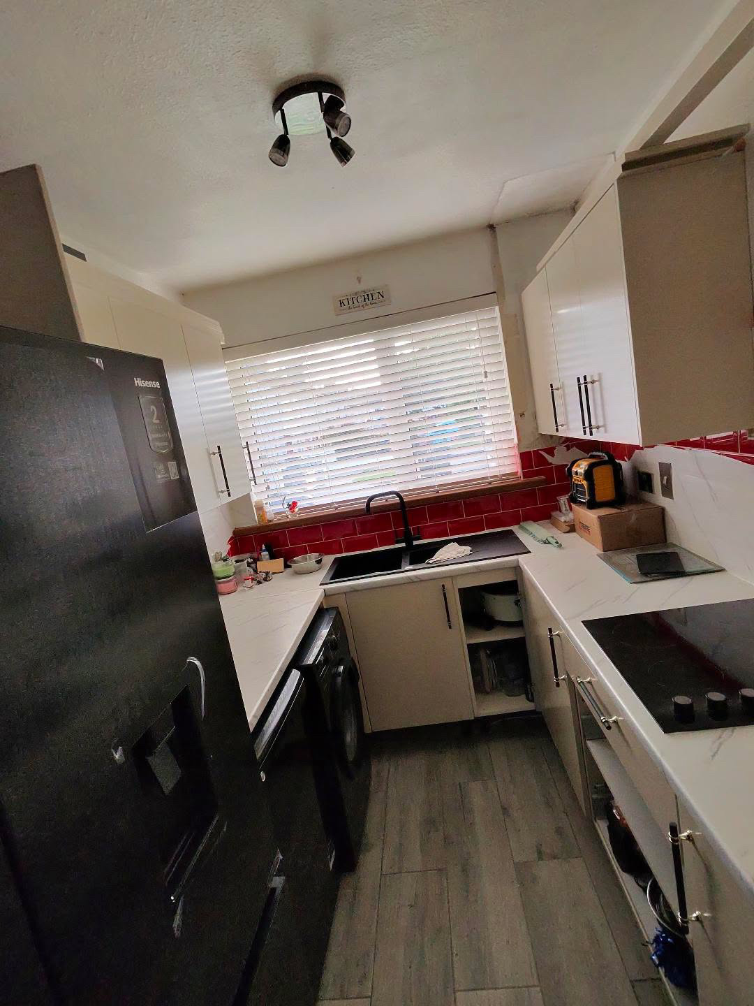 Fitted kitchen with light cabinet doors and pale worktops, view 1 of 13