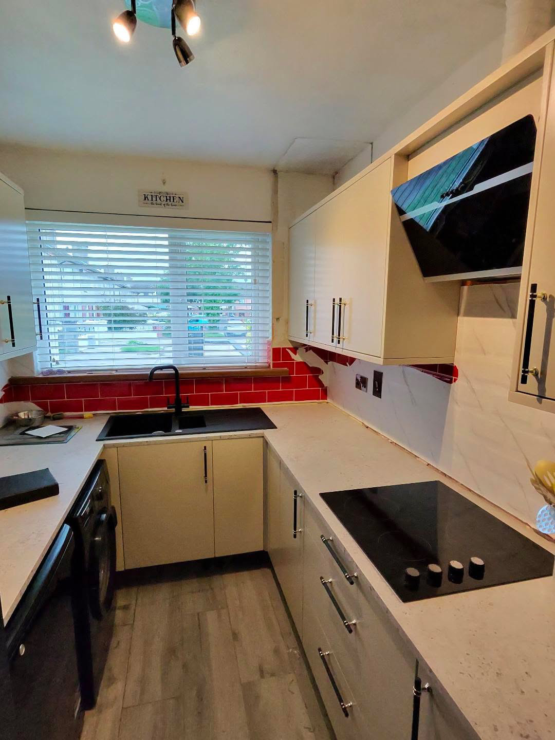 Fitted kitchen with light cabinet doors and pale worktops, view 2 of 13