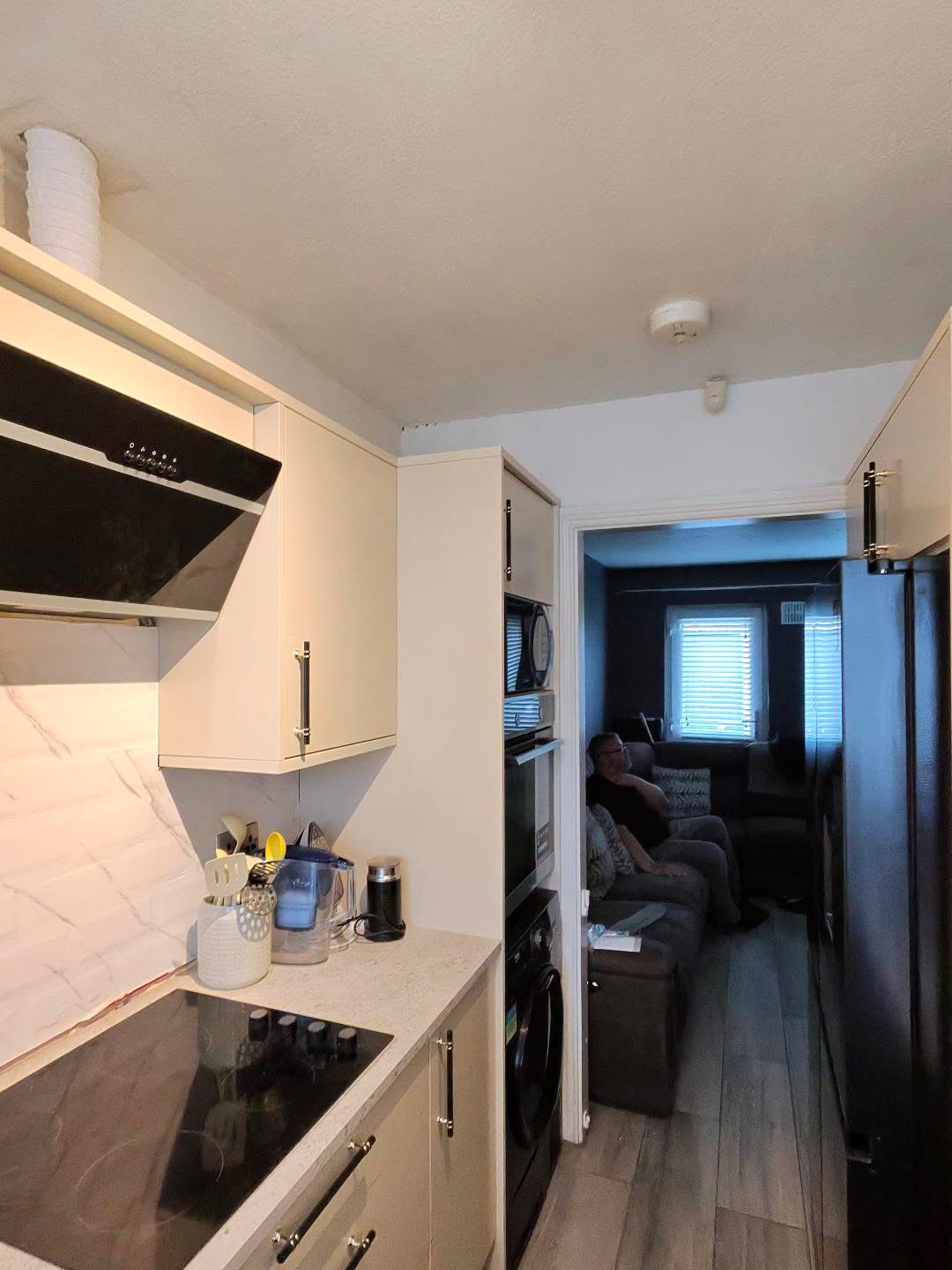 Fitted kitchen with light cabinet doors and pale worktops, view 4 of 13
