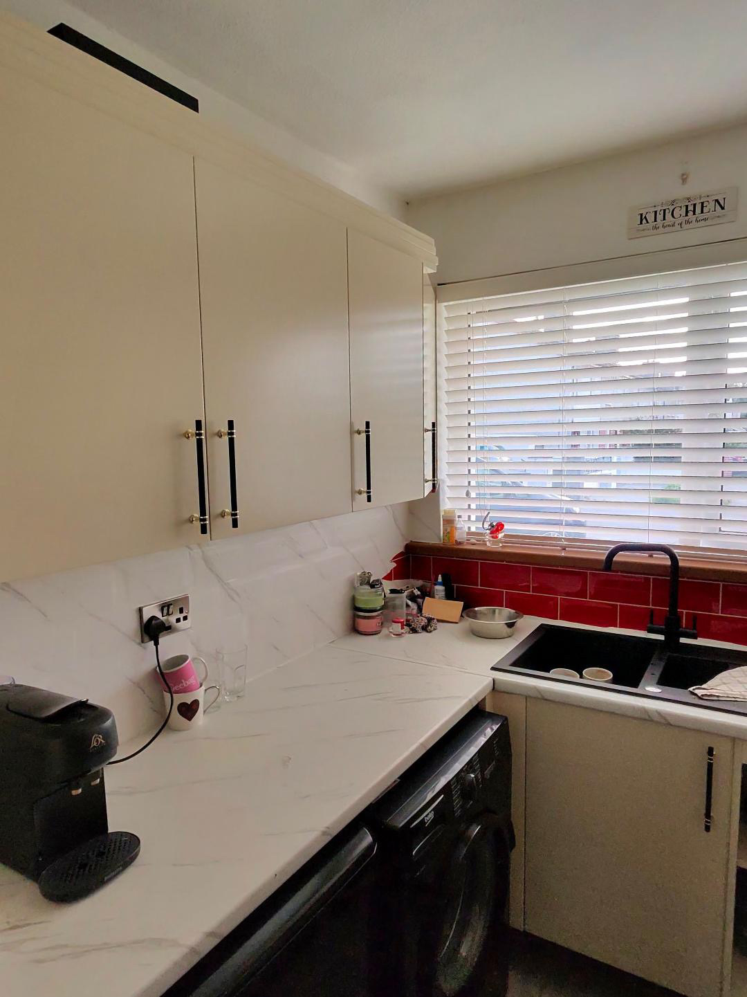 Fitted kitchen with light cabinet doors and pale worktops, view 5 of 13
