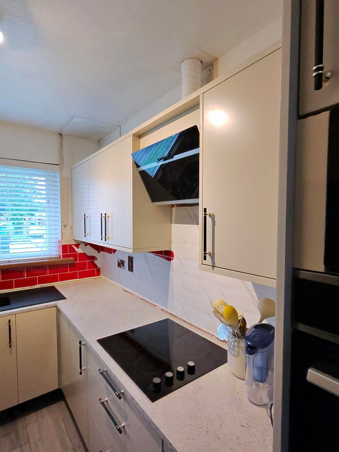 Fitted kitchen with light cabinet doors and pale worktops, view 6 of 13