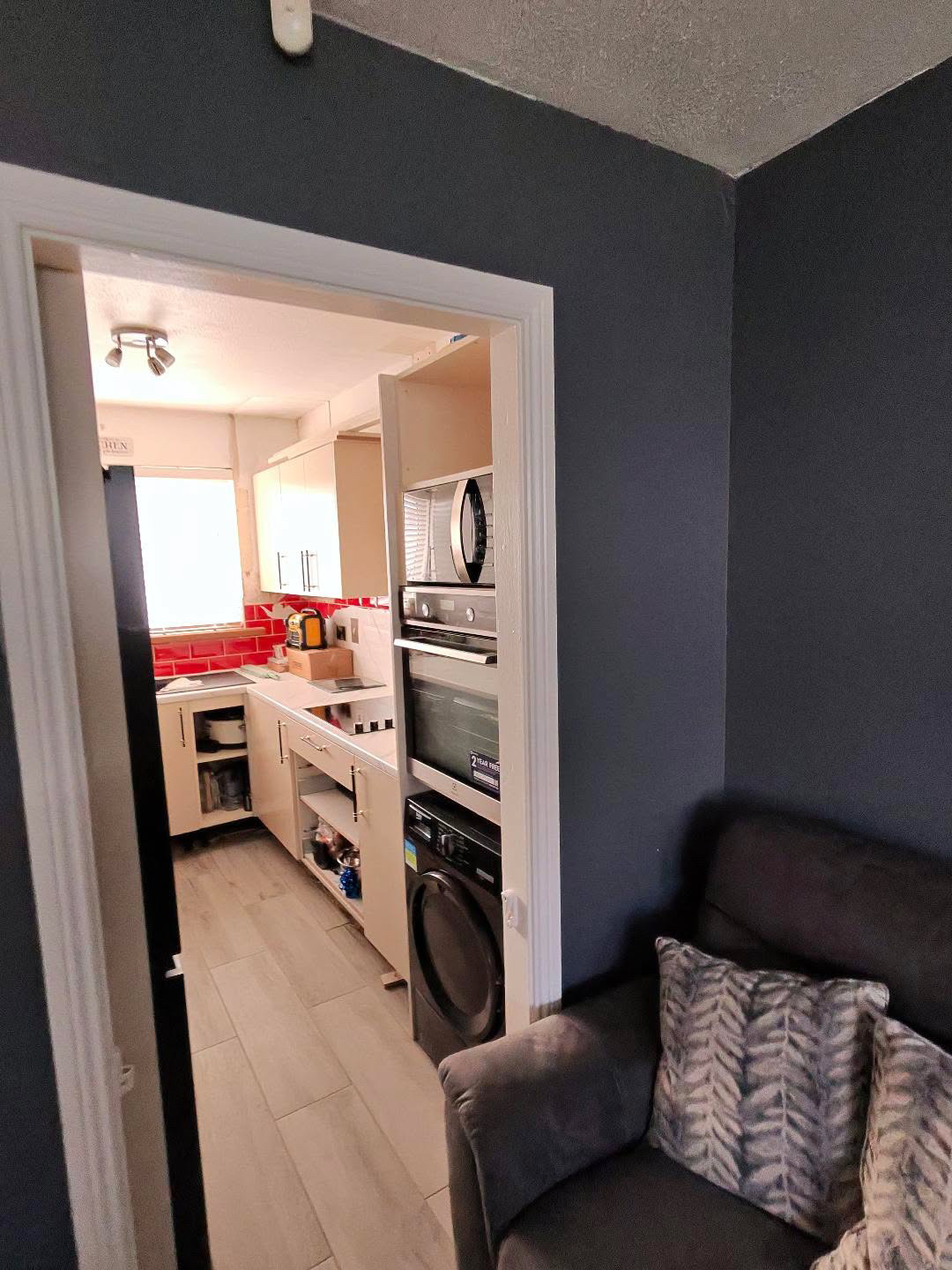 Fitted kitchen with light cabinet doors and pale worktops, view 7 of 13