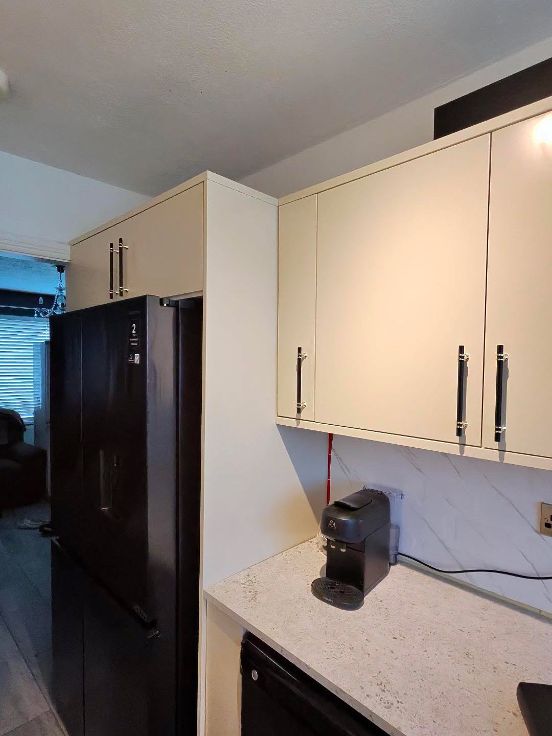 Fitted kitchen with light cabinet doors and pale worktops, view 9 of 13