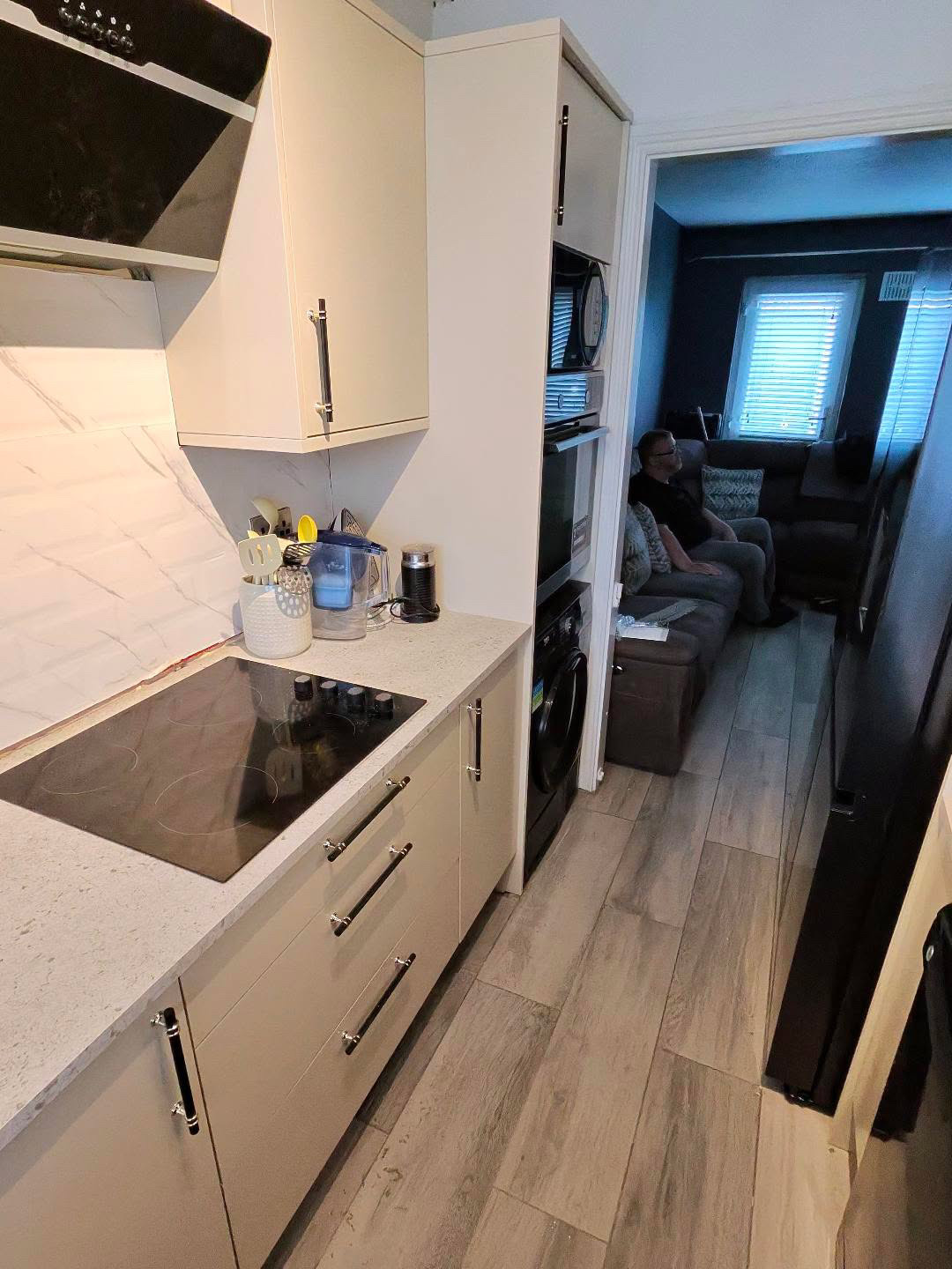 Fitted kitchen with light cabinet doors and pale worktops, view 11 of 13