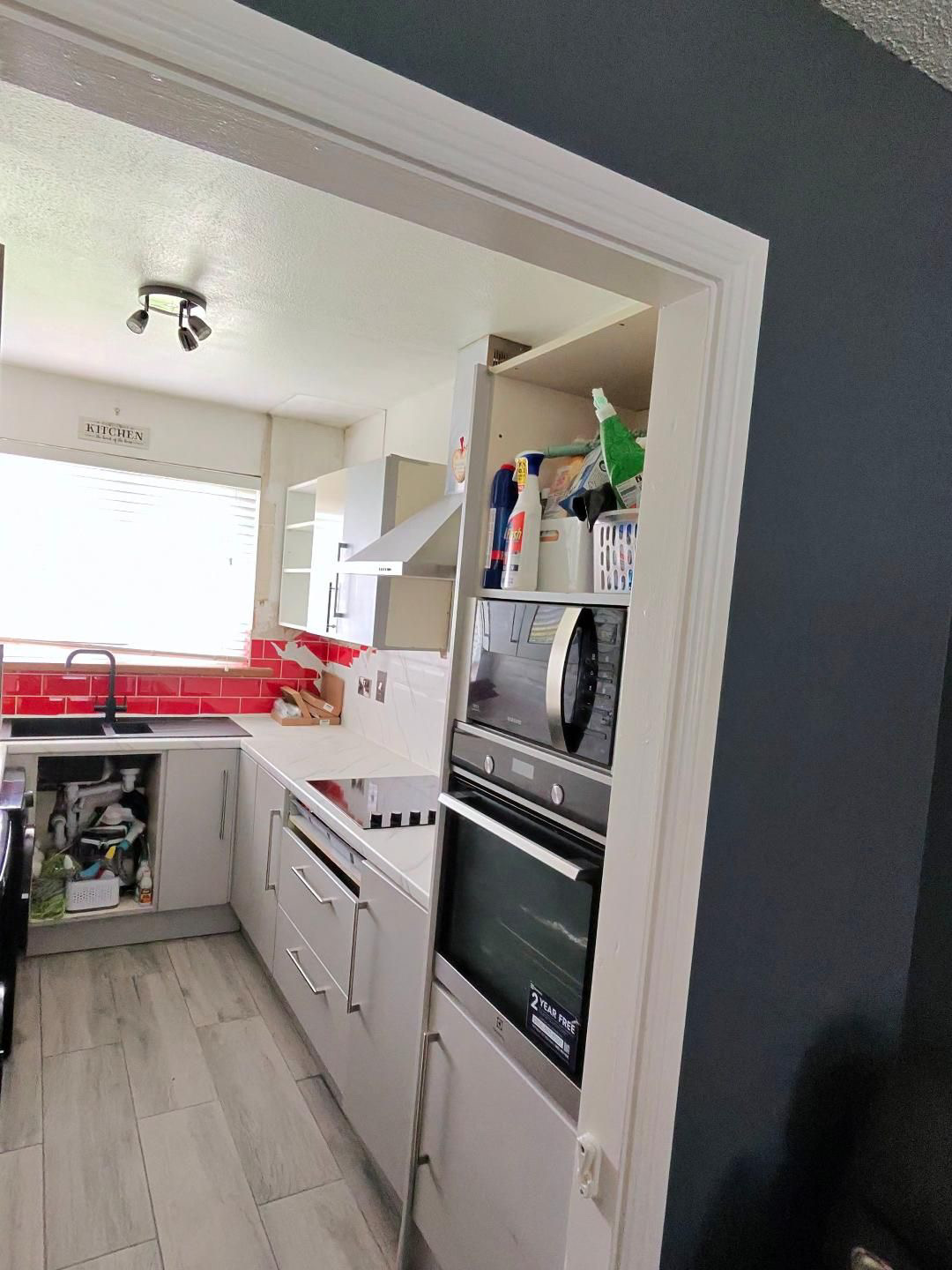 Fitted kitchen with light cabinet doors and pale worktops, view 12 of 13